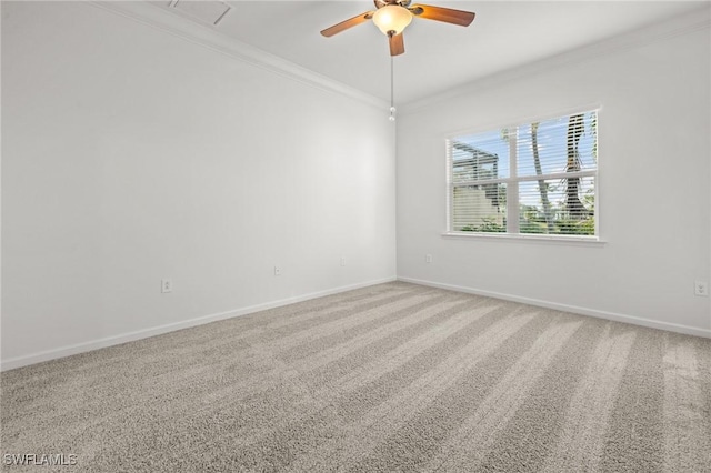 carpeted spare room featuring baseboards, visible vents, ornamental molding, and ceiling fan