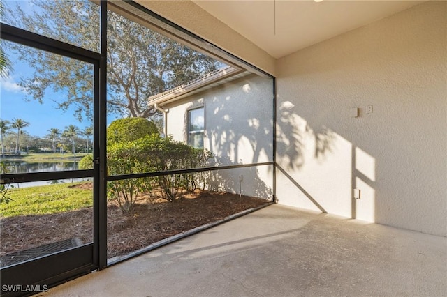 unfurnished sunroom featuring plenty of natural light and a water view