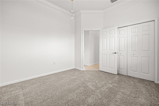 unfurnished bedroom featuring crown molding, carpet floors, and a closet