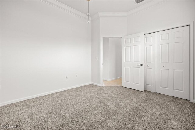 unfurnished bedroom with carpet, crown molding, a closet, visible vents, and baseboards