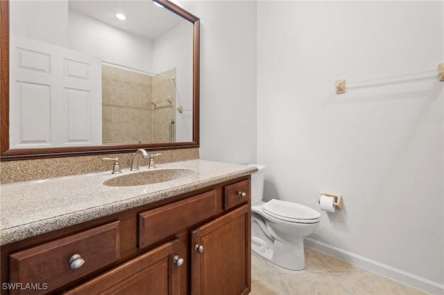 bathroom with tile patterned flooring, vanity, toilet, and tiled shower