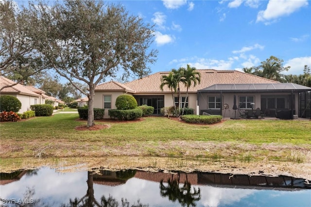 back of house with a lanai and a lawn