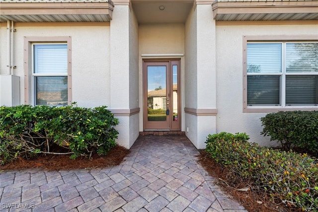 doorway to property featuring stucco siding