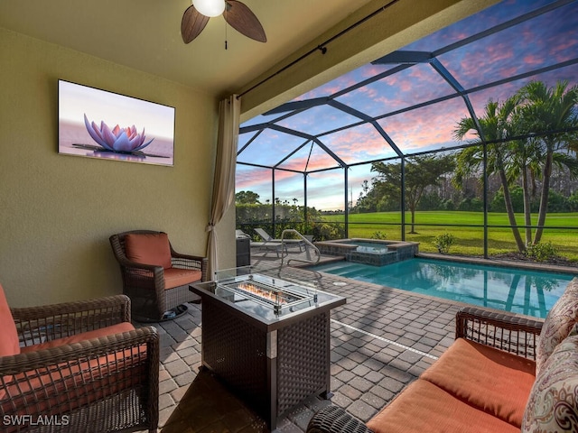 pool at dusk with an in ground hot tub, a lanai, an outdoor living space with a fire pit, and a patio area