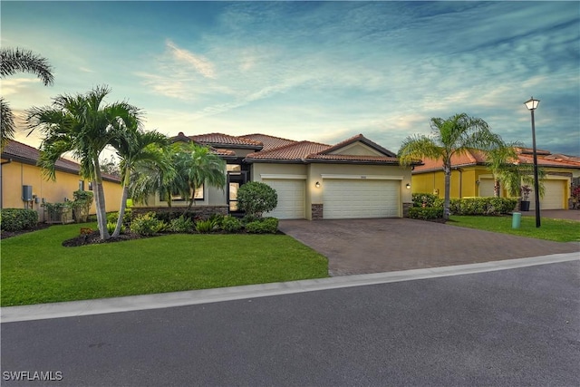 view of front of property with a yard and a garage