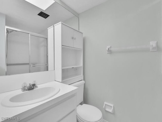 bathroom featuring an enclosed shower, vanity, and toilet