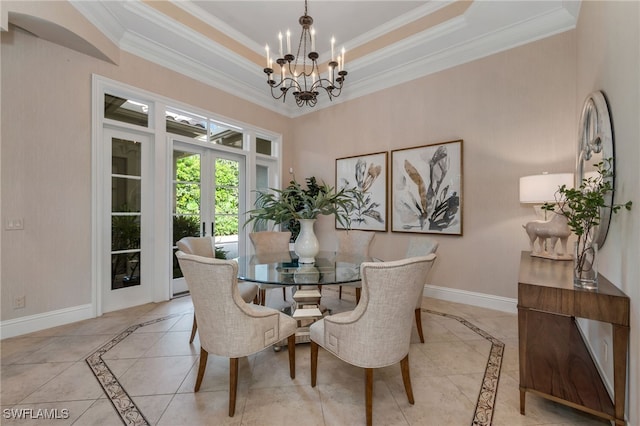 dining space featuring a raised ceiling, crown molding, a notable chandelier, and french doors