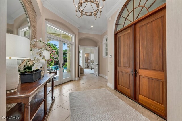 455 1st Ave N, Naples, FL 34102 - entrance foyer with ornamental molding, french doors, a chandelier, light tile patterned flooring, and baseboards