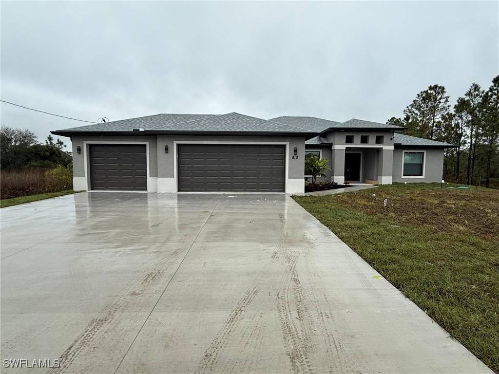 prairie-style home with a garage and a front yard