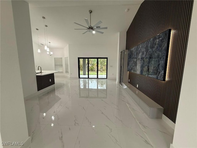 interior space with sink, ceiling fan, and a high ceiling