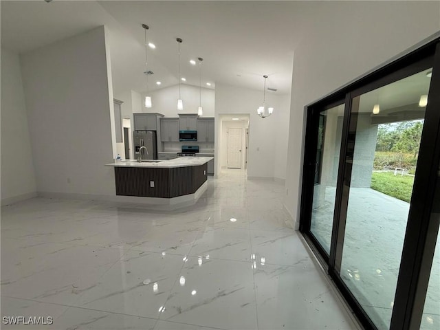 kitchen with a large island, sink, stainless steel appliances, high vaulted ceiling, and decorative light fixtures