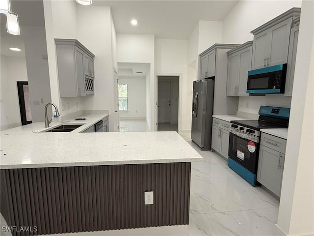 kitchen featuring stainless steel appliances, sink, gray cabinets, and kitchen peninsula