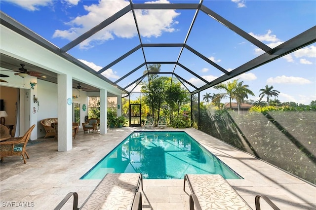 view of pool with a patio area, ceiling fan, and glass enclosure