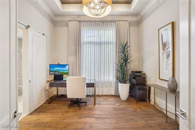 office featuring a notable chandelier, crown molding, wood-type flooring, and a raised ceiling