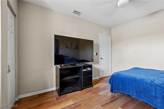 bedroom featuring visible vents, baseboards, and wood finished floors