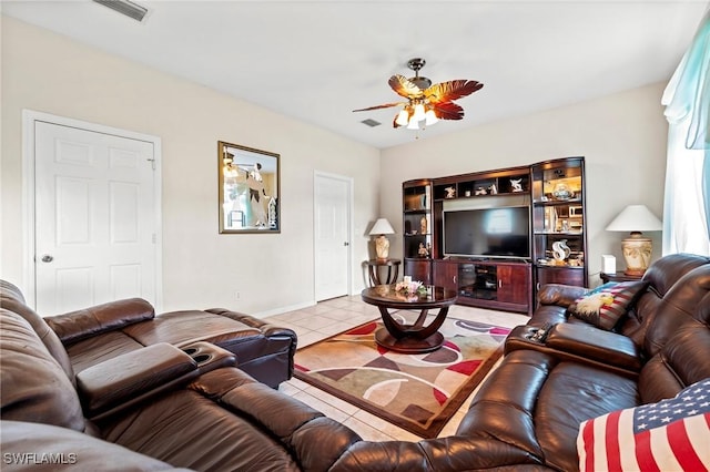 living area featuring a ceiling fan, visible vents, baseboards, and light tile patterned floors