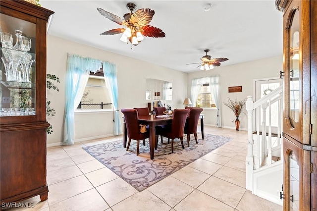 dining room featuring light tile patterned flooring, a ceiling fan, and baseboards