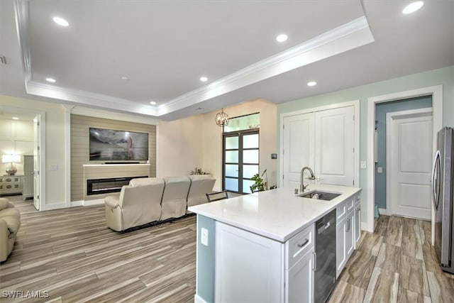 kitchen featuring white cabinetry, sink, a kitchen island with sink, and a tray ceiling