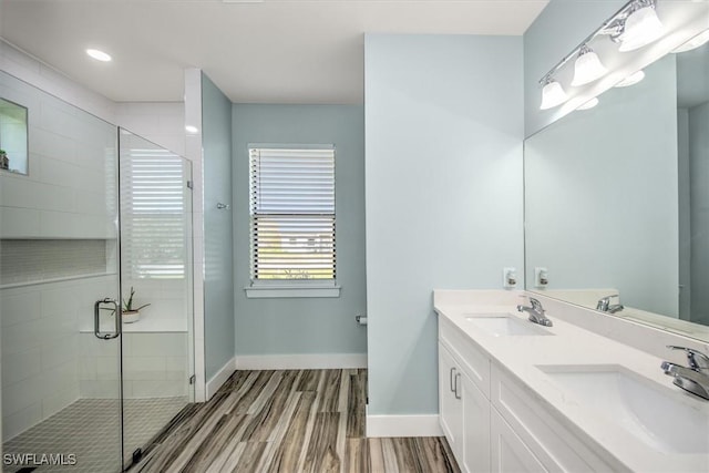 bathroom featuring vanity, wood-type flooring, and walk in shower