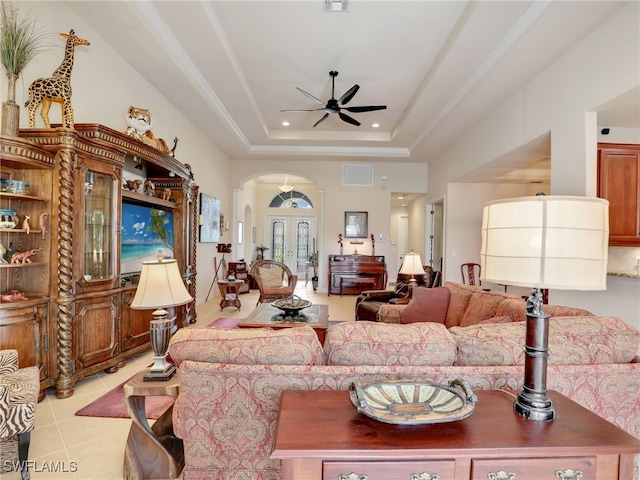 tiled living room featuring a raised ceiling, ceiling fan, and french doors