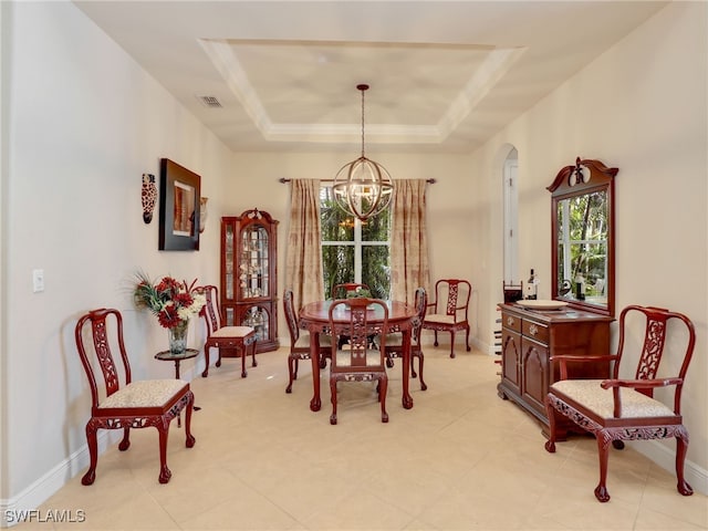 dining area with a raised ceiling and an inviting chandelier