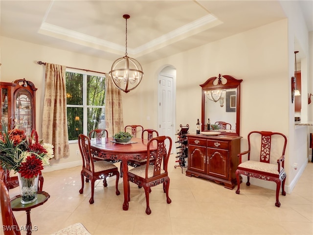 dining room featuring a raised ceiling, ornamental molding, and a notable chandelier