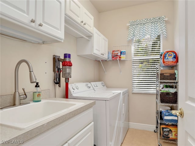 laundry area with cabinets, sink, light tile patterned floors, and washing machine and clothes dryer