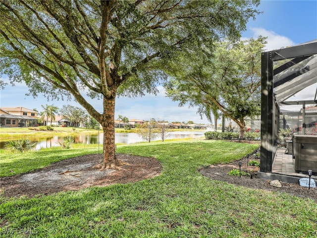 view of yard featuring a lanai and a water view