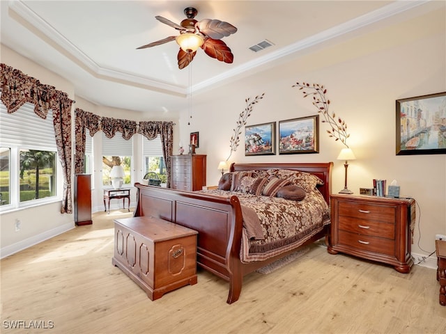 bedroom featuring ornamental molding, light hardwood / wood-style floors, a raised ceiling, and ceiling fan