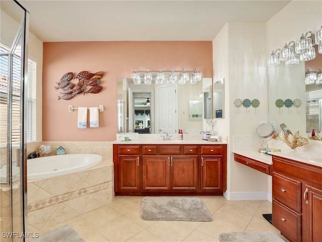 bathroom with tile patterned flooring, vanity, and a relaxing tiled tub