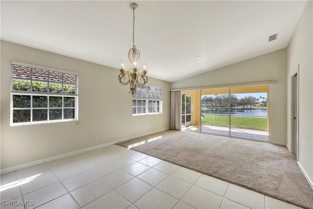 carpeted spare room with vaulted ceiling, a water view, a healthy amount of sunlight, and an inviting chandelier