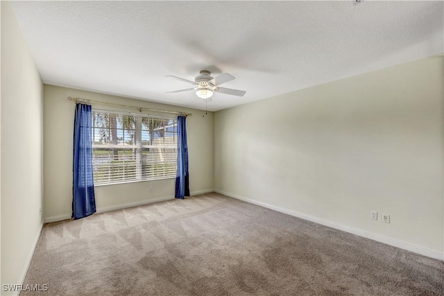 empty room featuring ceiling fan, light colored carpet, and a textured ceiling