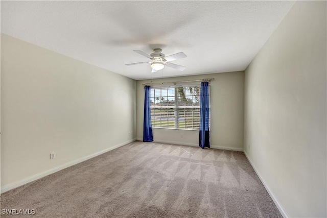 empty room featuring light colored carpet and ceiling fan