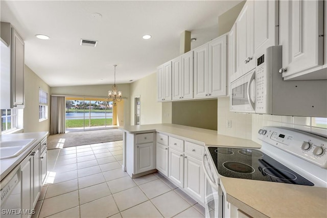 kitchen with white appliances, white cabinetry, tasteful backsplash, decorative light fixtures, and kitchen peninsula