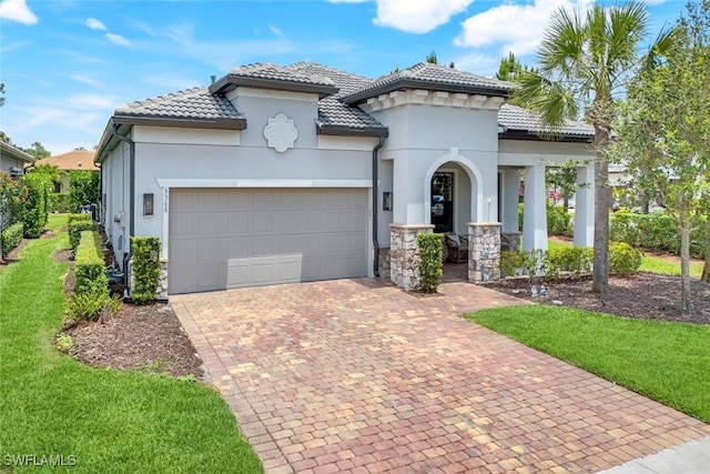 9368 Night Heron Ln, Naples, FL 34120 - mediterranean / spanish house with a garage, stucco siding, decorative driveway, and a tiled roof