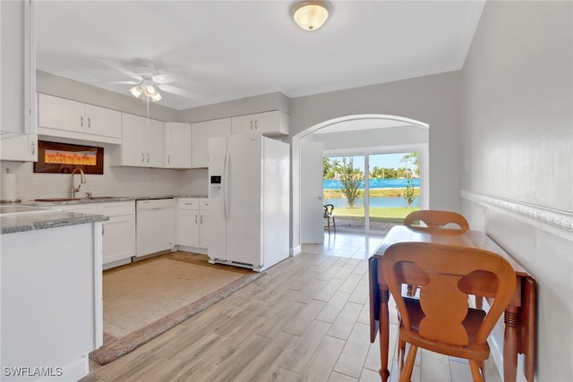 kitchen featuring sink, light wood-type flooring, white cabinets, ceiling fan, and white appliances