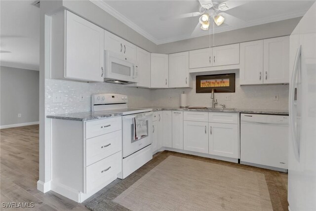 kitchen featuring sink, white appliances, crown molding, white cabinetry, and tasteful backsplash