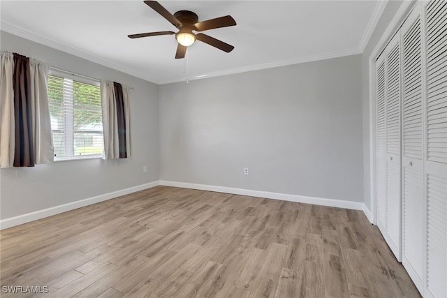 unfurnished bedroom featuring crown molding, ceiling fan, light wood-type flooring, and a closet