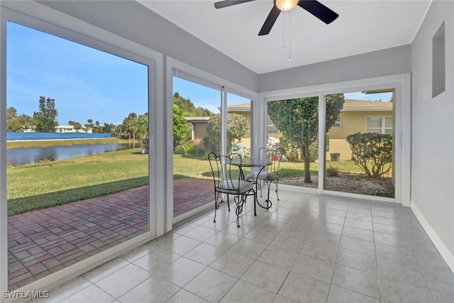 unfurnished sunroom featuring ceiling fan and a water view