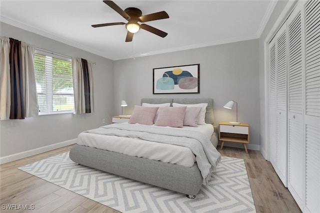 bedroom featuring ornamental molding, light hardwood / wood-style floors, a closet, and ceiling fan