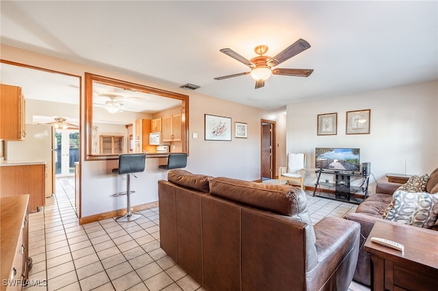 living room featuring light tile patterned flooring and ceiling fan