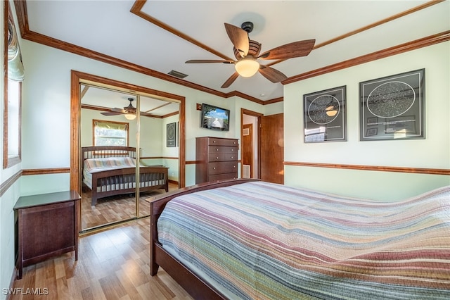 bedroom featuring hardwood / wood-style flooring, ornamental molding, and ceiling fan