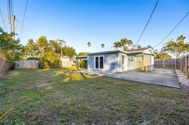 rear view of property with a yard, a patio area, and french doors