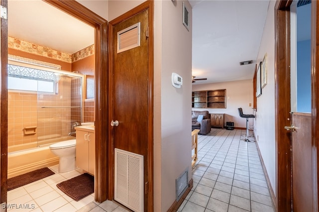 full bathroom with tile patterned flooring, vanity, bath / shower combo with glass door, and toilet