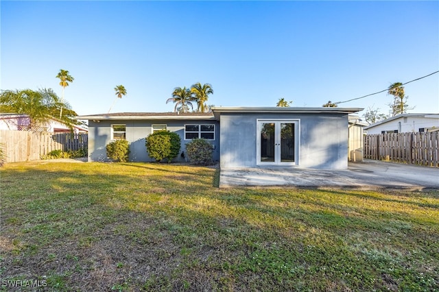 back of house with a lawn, french doors, and a patio area