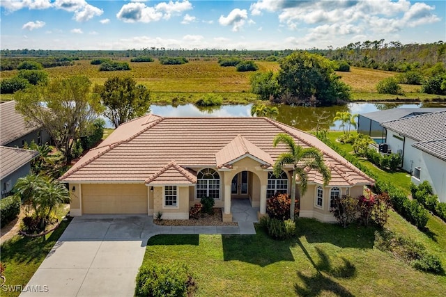 view of front of house featuring a garage, a front lawn, and a water view