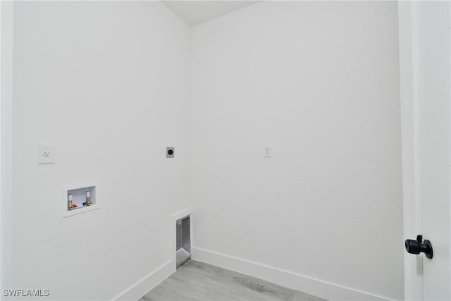 clothes washing area with hookup for a washing machine, hookup for an electric dryer, and light wood-type flooring