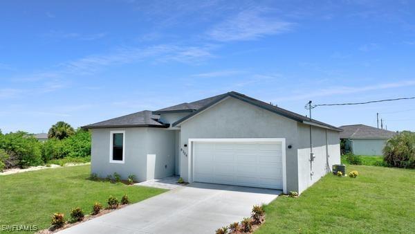 single story home featuring a garage and a front yard