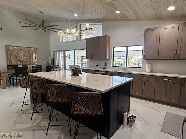 kitchen with pendant lighting, sink, wood ceiling, a kitchen island, and a kitchen bar