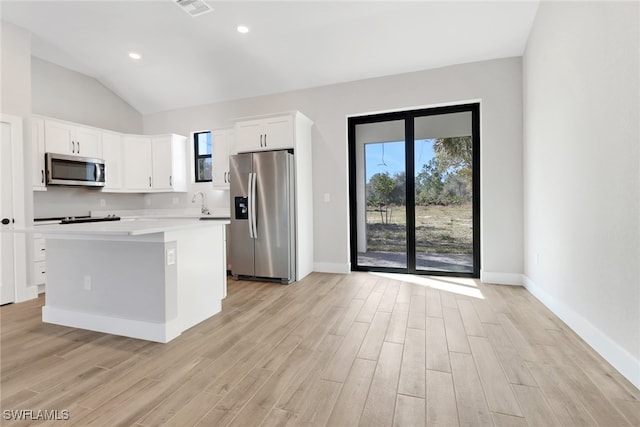 kitchen featuring a center island, plenty of natural light, stainless steel appliances, light hardwood / wood-style floors, and white cabinets